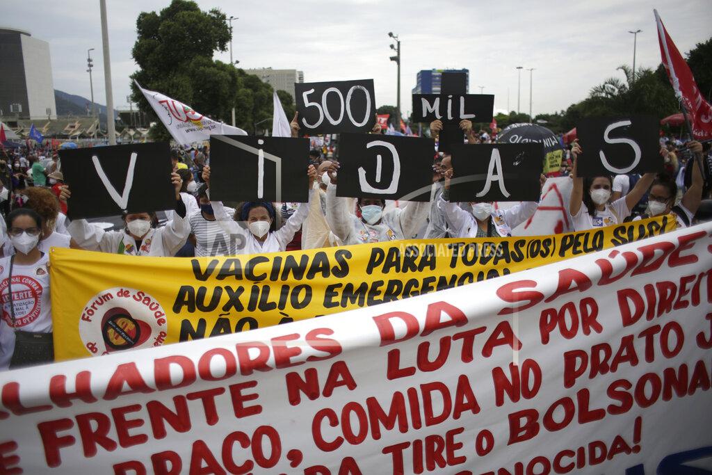 Bruna Prado Women simultaneously hold up placards with a message that reads in Portuguese; "500K deaths! His fault!" during a demonstration against Brazilian President Jair Bolsonaro's handling of the coronavirus pandemic and economic policies protesters say harm the interests of the poor and working class, in Rio de Janeiro, Brazil, Saturday, June 19, 2021. Brazil is approaching an official COVID-19 death toll of 500,000 — second-highest in the world. (AP Photo/Bruna Prado)