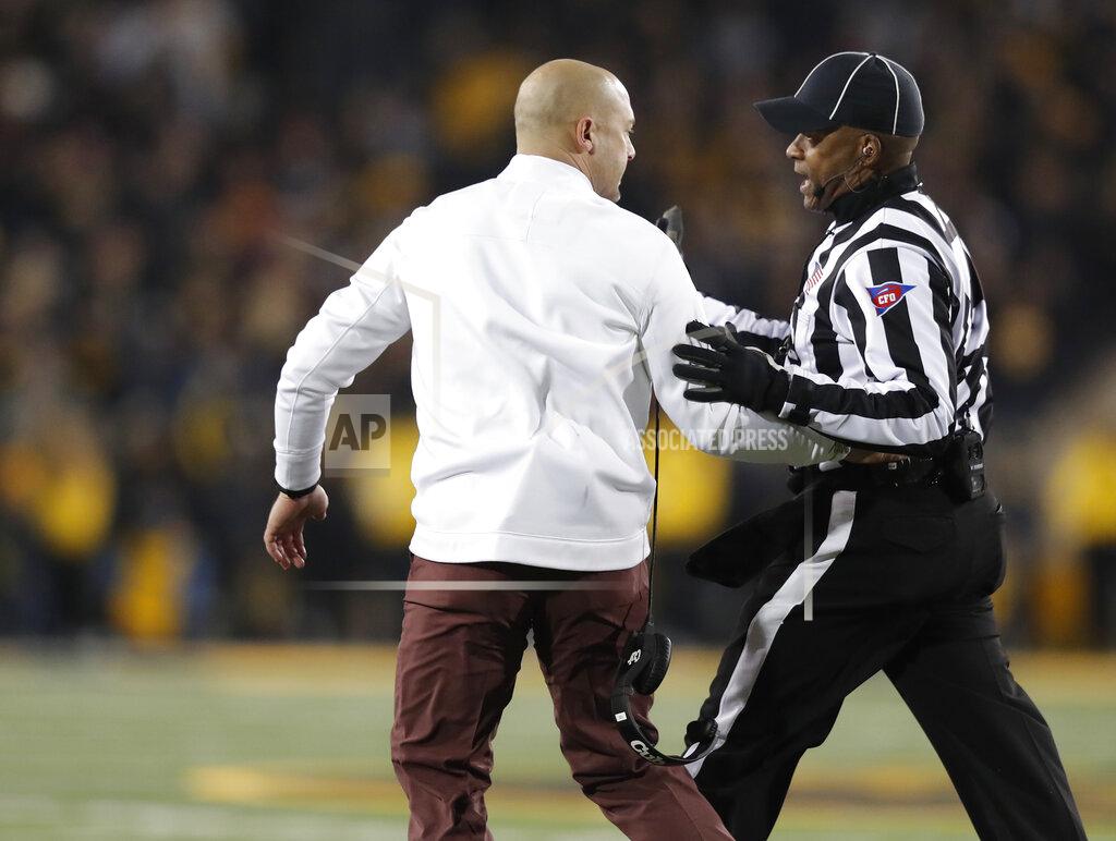 Matthew Putney Minnesota head coach P.J. Fleck, left, is escorted back to the sideline by an official after running onto the field after a play during the second half of an NCAA college football game against Iowa, Saturday, Nov. 16, 2019, in Iowa City, Iowa. (AP Photo/Matthew Putney)
