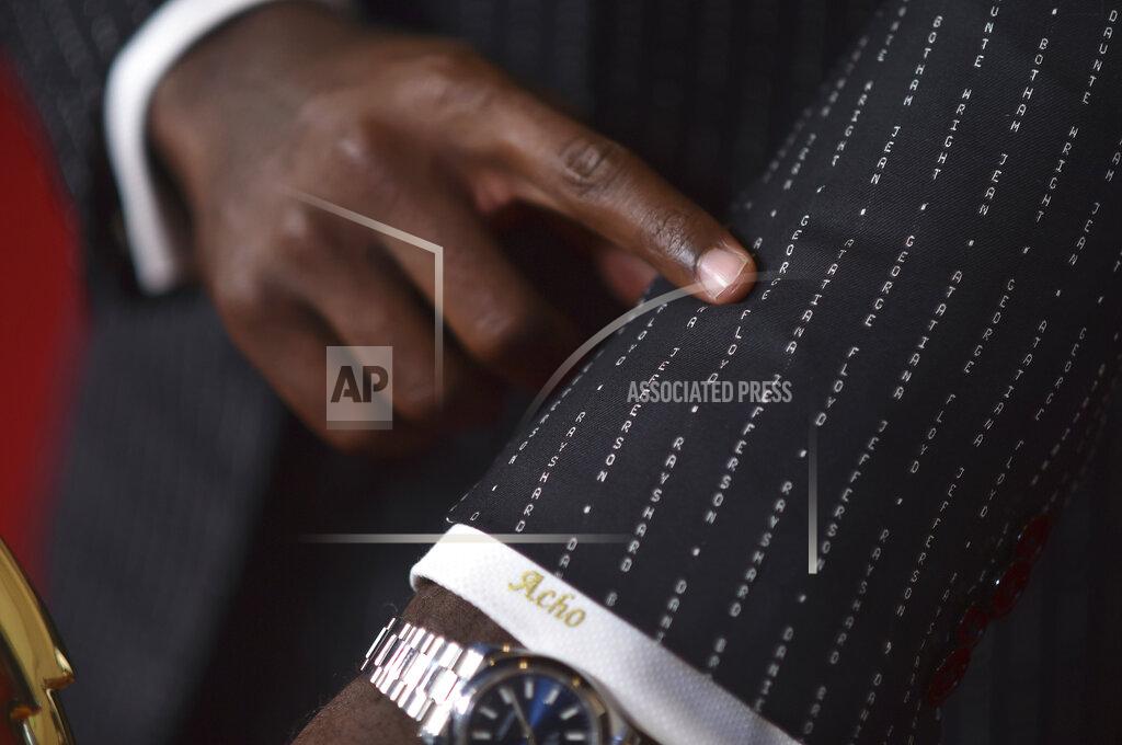 Richard Shotwell Emmanuel Acho points to George Floyd's name on his suit as he poses with the award for short form nonfiction or reality series for "Uncomfortable Conversations with a Black Man," on night two of the Creative Arts Emmy Awards on Sunday, Sept. 12, 2021, in Los Angeles. Acho wore a suit bearing the names of Black Americans killed at the hands of police. (Photo by Richard Shotwell/Invision/AP)