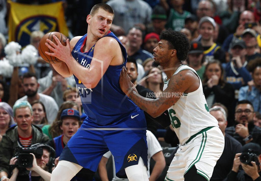 Denver Nuggets center Nikola Jokic, left, looks to pass the ball as Boston Celtics guard Marcus Smart defends during the second half of an NBA basketball game Friday, Nov. 22, 2019, in Denver. The Nuggets won 96-92. (AP Photo/David Zalubowski)