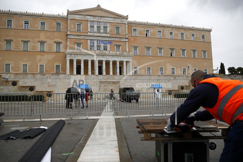 Thanassis Stavrakis A worker uses a power saw to cut boards, for the officials' tribune, in front of the Greek Parliament ahead of a military parade, in Athens, Tuesday, March 23, 2021. The military parade on March 25, marking 200-years since the war that resulted in Greece's independence from the Ottoman Empire and rebirth as a nation, will be held without spectators due to the coronavirus. (AP Photo/Thanassis Stavrakis)