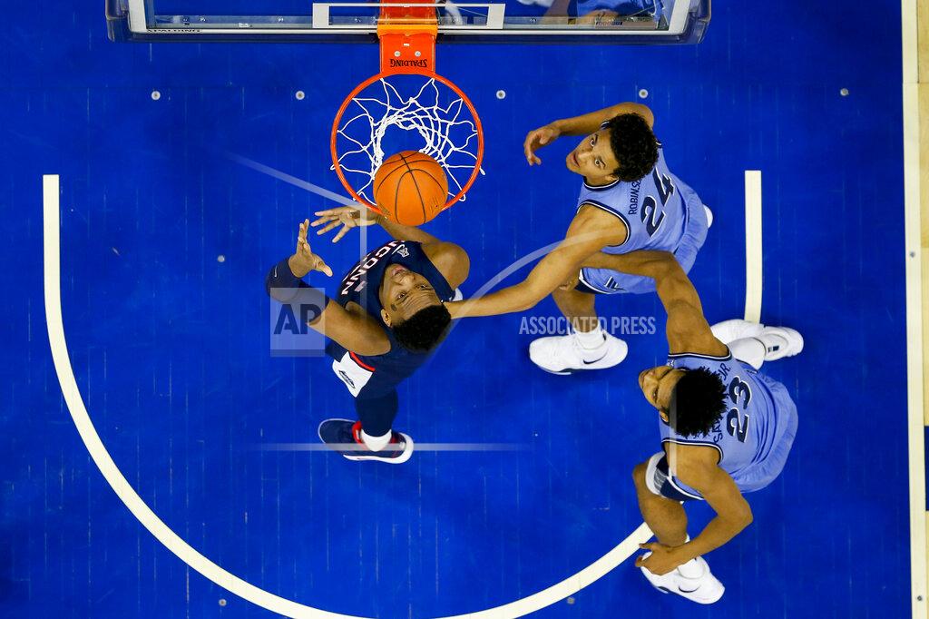 Chris Szagola Connecticut's Josh Carlton, left, shoots the ball with Villanova's Jeremiah Robinson-Earl, center, and Jermaine Samuels, right, defending during the first half of an NCAA college basketball game Saturday, Jan. 18, 2020, in Philadelphia. (AP Photo/Chris Szagola)