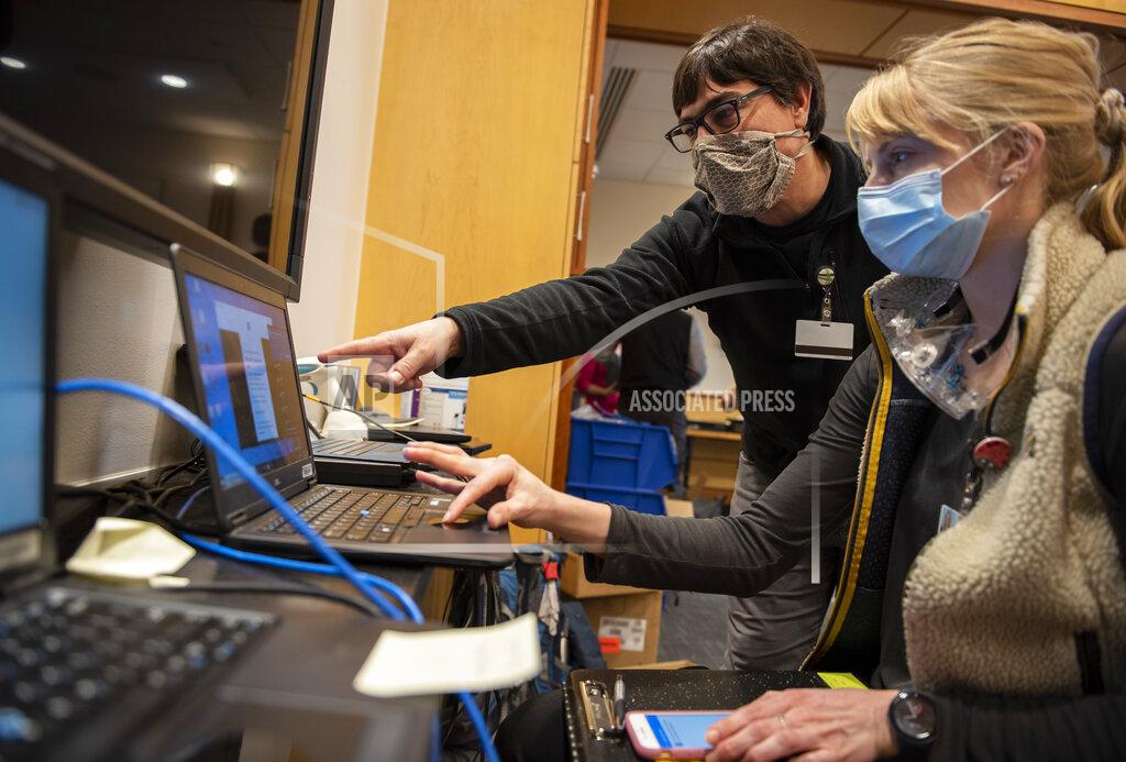 Ryan Mercer In this photo provided by the University of Vermont Health Network, IT staff help clinical providers set up new computers at the University of Vermont Medical Center in Burlington, Vt., on Friday, Nov. 20, 2020. After the Oct. 28 attack forced a shutdown of the hospital’s electronic medical records and other key systems, the IT department, with support from the Vermont National Guard’s cyber team, scanned thousands of computers for malware and replaced machines for hospital staff. (Ryan Mercer/University of Vermont Health Network via AP)