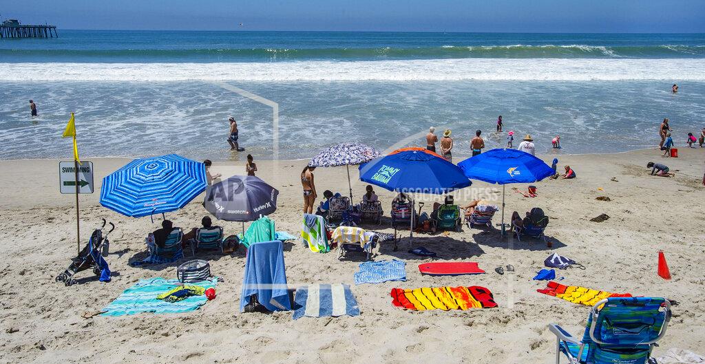 Mark Rightmire With most of Southern California's coastline is shut down for the Fourth of July holiday due to a spike in coronavirus cases, the beach in San Clemente, Calif., remains open as crowds, socially distanced, fill the sand Saturday, July 4, 2020. (Mark Rightmire/The Orange County Register via AP)