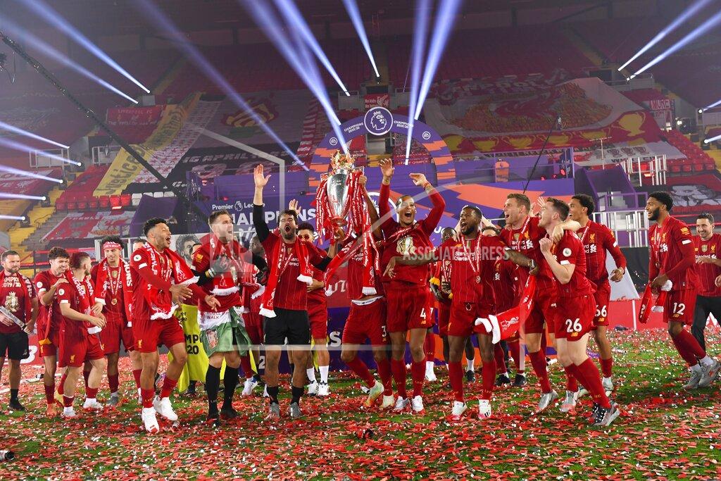 Laurence Griffiths Liverpool players celebrate with the English Premier League trophy following the English Premier League soccer match between Liverpool and Chelsea at Anfield Stadium in Liverpool, England, Wednesday, July 22, 2020. Liverpool are champions of the EPL for the season 2019-2020. The trophy is presented at the teams last home game of the season. Liverpool won the match against Chelsea 5-3. (Laurence Griffiths, Pool via AP)