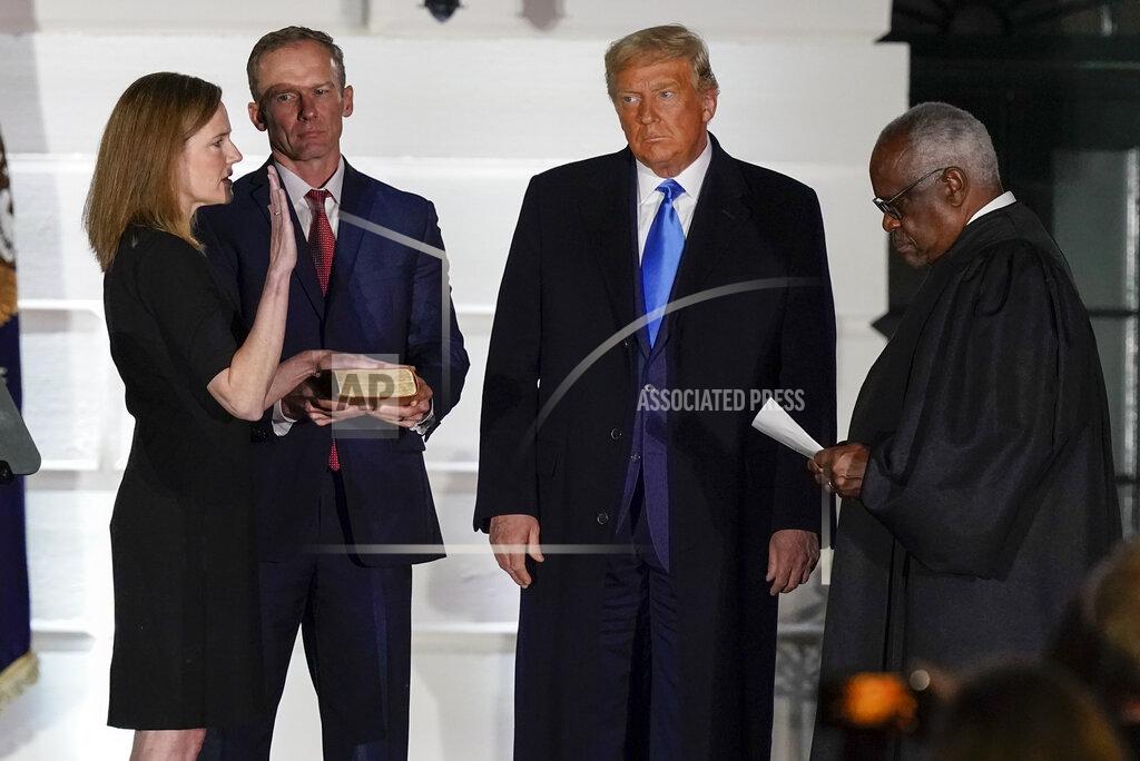 Alex Brandon President Donald Trump watches as Supreme Court Justice Clarence Thomas administers the Constitutional Oath to Amy Coney Barrett on the South Lawn of the White House White House in Washington, Monday, Oct. 26, 2020, after Barrett was confirmed to be a Supreme Court justice by the Senate earlier in the evening. Holding the Bible is Barrett's husband, Jesse Barrett. (AP Photo/Alex Brandon)