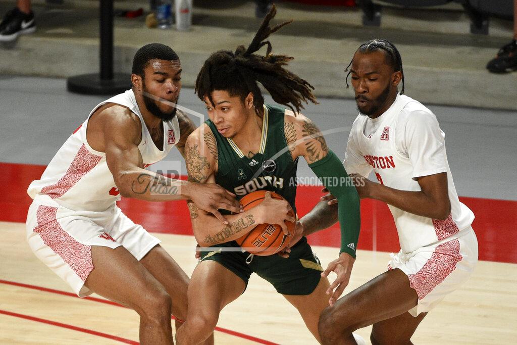 Eric Christian Smith South Florida guard Caleb Murphy, center, looks to pass as Houston forward Reggie Chaney, left, and guard DeJon Jarreau defend during the first half of an NCAA college basketball game, Sunday, Feb. 28, 2021, in Houston. (AP Photo/Eric Christian Smith)
