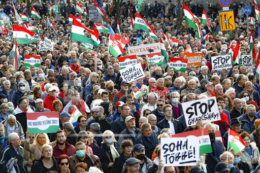 People hold banners that read "Never Again" during a march marking the 65th anniversary of the 1956 Hungarian revolution, in Budapest, Hungary, Saturday, Oct. 23, 2021. Thousands of supporters of Prime Minister Viktor Orban, who is expected to deliver a speech marking the 65th anniversary of the 1956 Hungarian revolution, march in Budapest, Hungary to demonstrate loyalty to his right-wing government. (AP Photo/Laszlo Balogh)