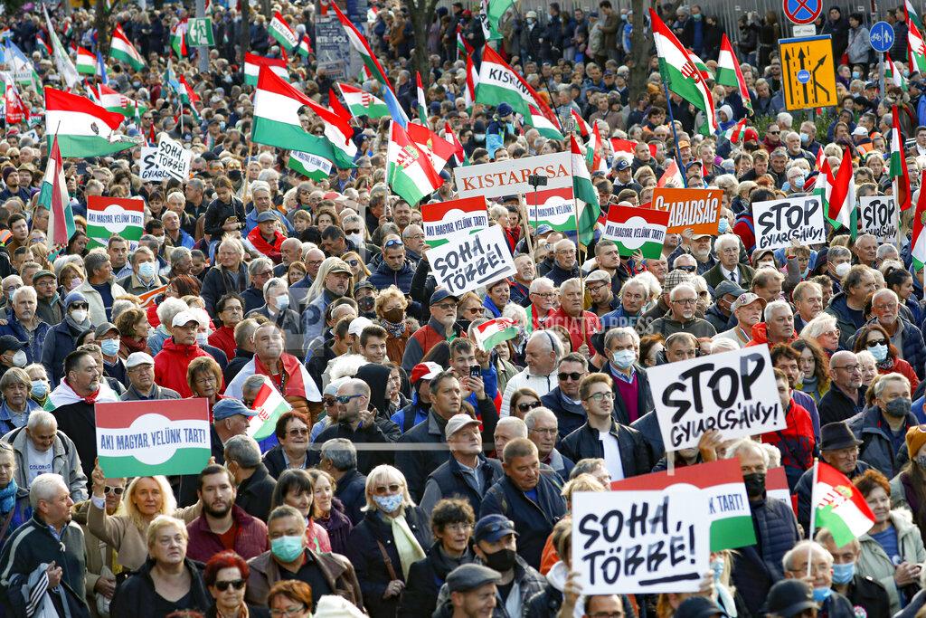 Laszlo Balogh People hold banners that read "Never Again" during a march marking the 65th anniversary of the 1956 Hungarian revolution, in Budapest, Hungary, Saturday, Oct. 23, 2021. Thousands of supporters of Prime Minister Viktor Orban, who is expected to deliver a speech marking the 65th anniversary of the 1956 Hungarian revolution, march in Budapest, Hungary to demonstrate loyalty to his right-wing government. (AP Photo/Laszlo Balogh)