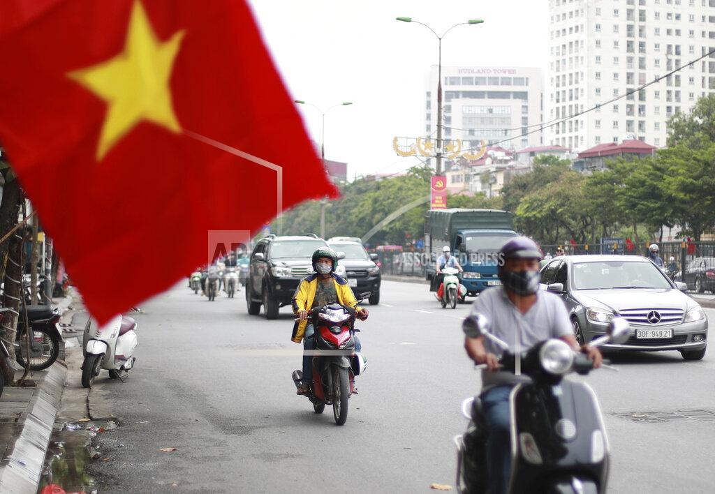 Hau Dinh People wearing face masks to help curb the spread of the coronavirus ride mopeds in Hanoi, Vietnam on Thursday, Aug. 6, 2020. Vietnamese health official said on Thursday the COVID-19 outbreak would peak in the coming ten days as the country reported another death and a score of new infections. (AP Photo/Hau Dinh)