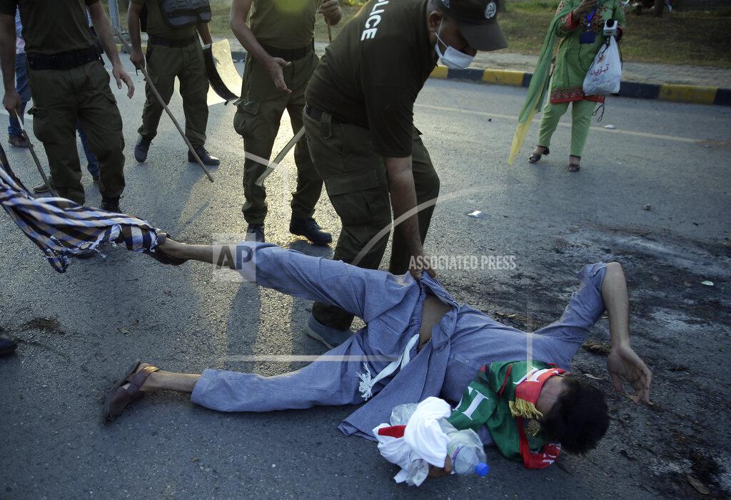 Rahmat Gul Police officers detain a protester during a march by supporters of Pakistan's key opposition, in Islamabad, Pakistan, Wednesday, May 25, 2022. Pakistani authorities blocked off all major roads into the capital Islamabad on Wednesday, after a defiant former Prime Minister Imran Khan said he would march with demonstrators to the city center for a rally he hopes will bring down the government and force early elections. (AP Photo/Rahmat Gul)