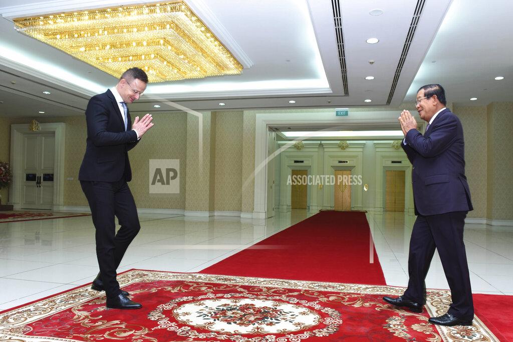 Hungarian Foreign Minister Peter Szijjarto, left, greets Cambodian Prime Minister Hun Sen prior to a meeting at Peace Palace in Phnom Penh, Cambodia, Tuesday, Nov. 3, 2020. Szijjarto tested positive for the coronavirus after arriving in Thailand for an official visit, Thai and Hungarian officials said Wednesday, Nov. 4, 2020. (Pool Photo via AP)