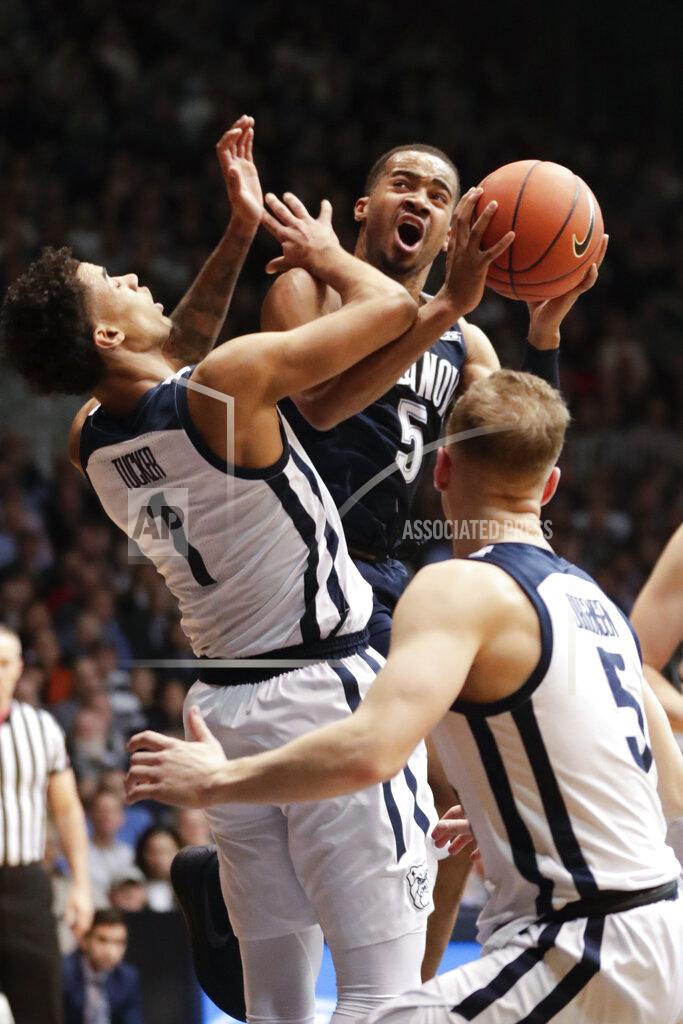 Michael Conroy Villanova guard Phil Booth (5) is fouled as he shoots by Butler forward Jordan Tucker (1) in the first half of an NCAA college basketball game in Indianapolis, Tuesday, Jan. 22, 2019. (AP Photo/Michael Conroy)