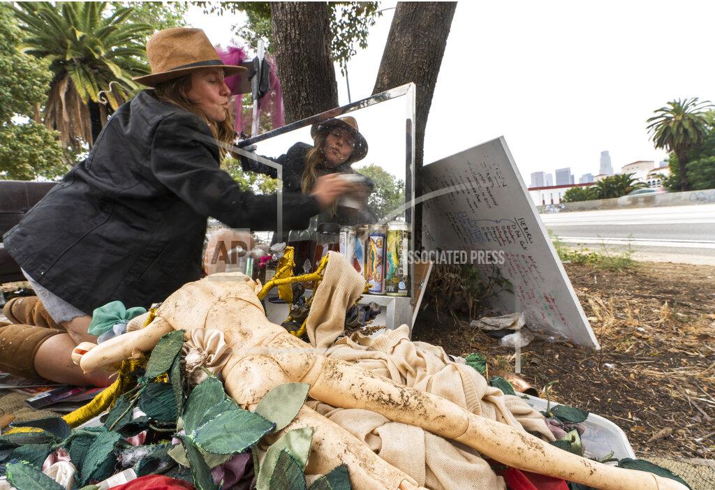 Dawn Woodward Dawn Woodward, 39, who is homeless and originally from Arizona, dusts a mirror set outdoors in a homeless camp on the side of the CA-101 highway in the Echo Park neighborhood in Los Angeles Tuesday, May 11, 2021. California Gov. Gavin Newsom on Tuesday proposed $12 billion in new funding to get more people experiencing homelessness in the state into housing and to “functionally end family homelessness” within five years. (AP Photo/Damian Dovarganes)