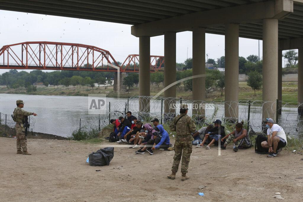 Dario Lopez-Mills Migrants who had crossed the Rio Grande river into the U.S. are under custody of National Guard members as they await the arrival of U.S. Border Patrol agents in Eagle Pass, Texas, Friday, May 20, 2022. As U.S. officials anxiously waited, many of the migrants crossing the border from Mexico on Friday were oblivious to a pending momentous court ruling on whether to maintain pandemic-related powers that deny a chance to seek asylum on grounds of preventing the spread of COVID-19. (AP Photo/Dario Lopez-Mills)