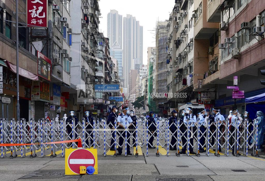 Vincent Yu Police officers stand guard at the Yau Ma Tei area in Hong Kong, Saturday, Jan. 23, 2021. Thousands of Hong Kong residents were locked down Saturday in an unprecedented move to contain a worsening outbreak in the city, authorities said. (AP Photo/Vincent Yu)