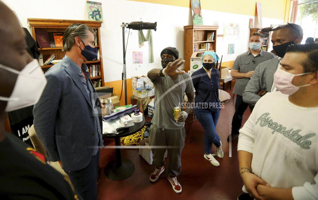 Genaro Molina California Gov. Gavin Newsom, second from left, listens to the concerns of Marcus Warren, center, while visiting the Hot and Cool Cafe in Leimert Park in Los Angeles on Wednesday, June 3, 2020. The cafe has been providing meals prepared at the establishment three days a week for older adults during the coronavirus pandemic stay at home order. (Genaro Molina/Los Angeles Times via AP, Pool)