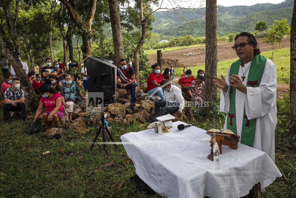 Rodrigo Abd Friar Leopoldo Serrano celebrates an outdoor Mass at Mission San Francisco de Asis, in Honduras, Sunday, June 27, 2021. The pastor of souls has turned into a project manager and construction foreman for the families of La Reina, a nearby Honduran village buried in an epic mudslide in November 2020, its families among nearly half a million Central Americans displaced by Hurricanes Eta and Iota. (AP Photo/Rodrigo Abd)