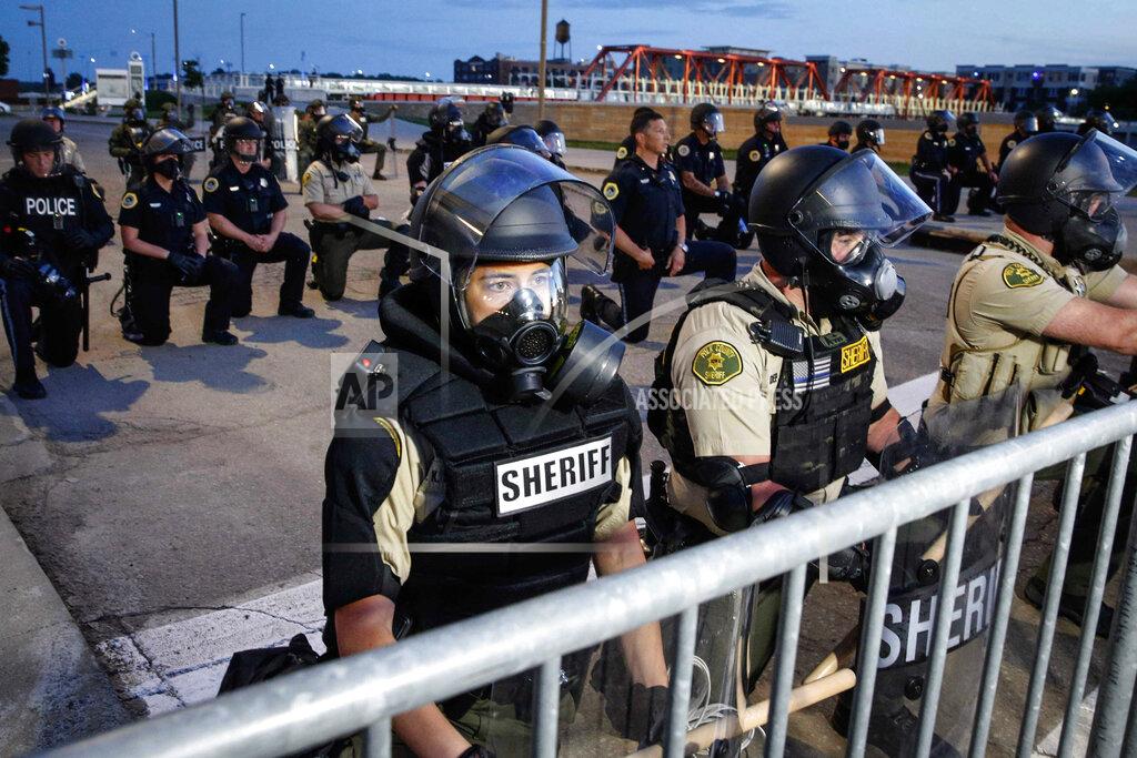 Bryon Houlgrave Police take their knees, uniting with protesters, in Des Moines, I.A. on Sunday, June 1, 2020. (Bryon Houlgrave /The Des Moines Register via AP )