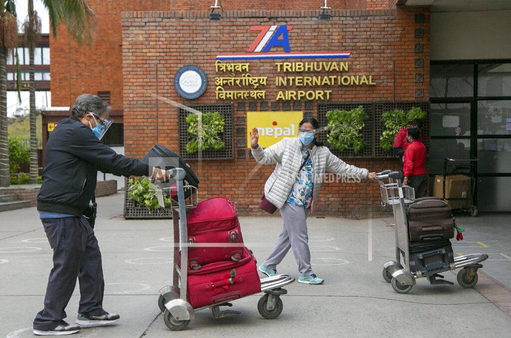Niranjan Shrestha Passengers wearing face masks arrive to board departing flights at the Tribuvan International airport in Kathmandu, Nepal, Thursday, May 6, 2021. Thousands of passengers rushed to leave Nepal as the Himalayan nation halts all international flights from Thursday because of spiking cases of COVID-19. (AP Photo/Niranjan Shrestha)