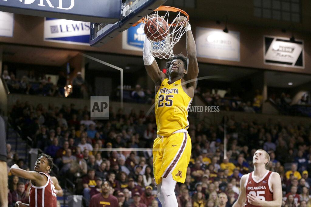 Nati Harnik Minnesota's Daniel Oturu (25) dunks as Oklahoma's Alondes Williams (15) and Brady Manek (35) watch during the second half of an NCAA college basketball game in Sioux Falls, S.D., Saturday, Nov. 9, 2019. (AP Photo/Nati Harnik)