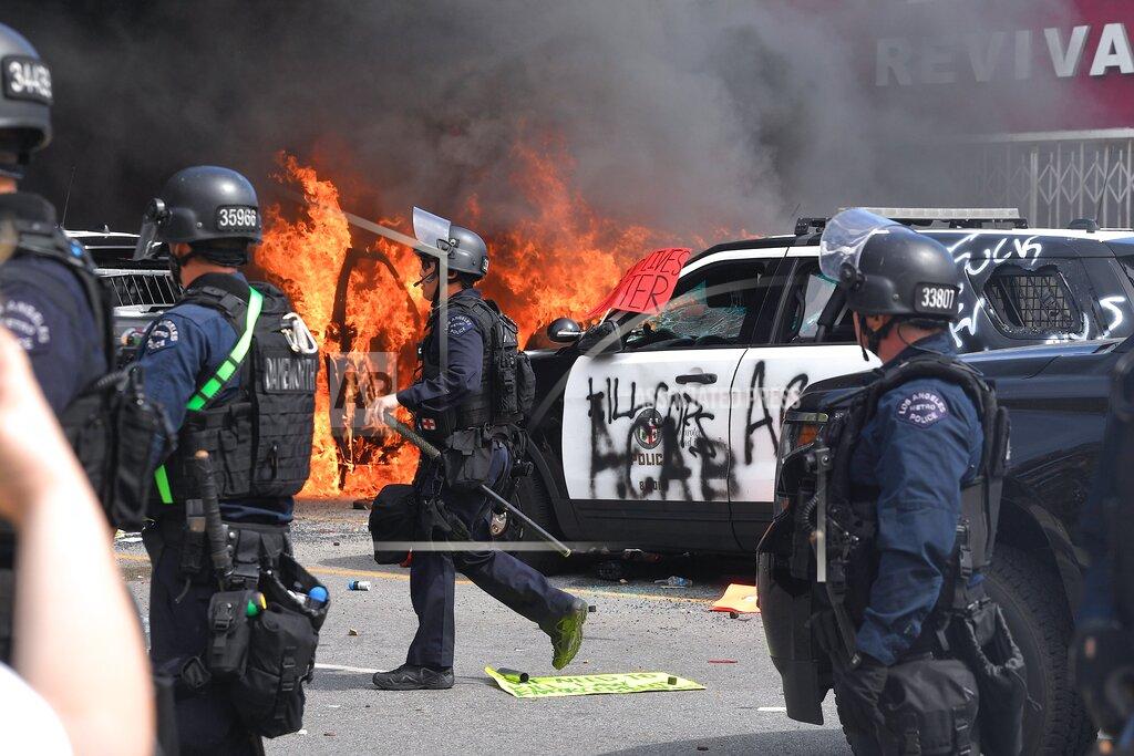 Mark J. Terrill A police car burns as another one is seen destroyed during a protest over the death of George Floyd Saturday, May 30, 2020, in Los Angeles. Floyd died in police custody on May 25 in Minneapolis. (AP Photo/Mark J. Terrill)