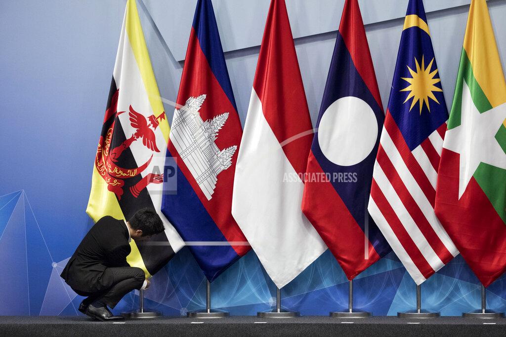 Bernat Armangue FIEL - In this Nov. 13, 2018, file photo, a worker adjusts the Brunei Darussalam flag prior the 22nd ASEAN coordinating council meeting on the sidelines of the 33rd ASEAN summit in Singapore. China is hosting foreign ministers from 10 Southeast Asian nations amid heightened competition between Beijing and Washington for influence in the region. (AP Photo/Bernat Armangue, File)