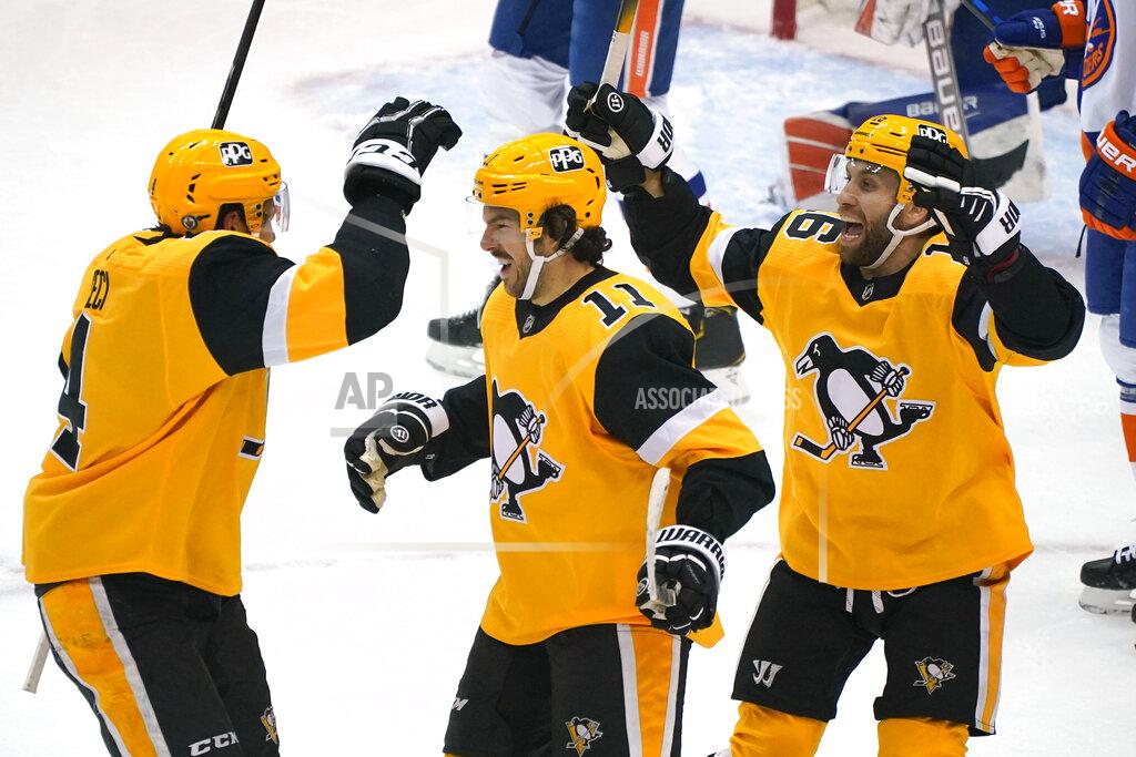 Gene J. Puskar Pittsburgh Penguins' Frederick Gaudreau (11) celebrates his goal with Cody Ceci, left, and Jason Zucker during the first period of Game 1 of an NHL hockey Stanley Cup first-round playoff series against the New York Islanders in Pittsburgh, Sunday, May 16, 2021. (AP Photo/Gene J. Puskar)