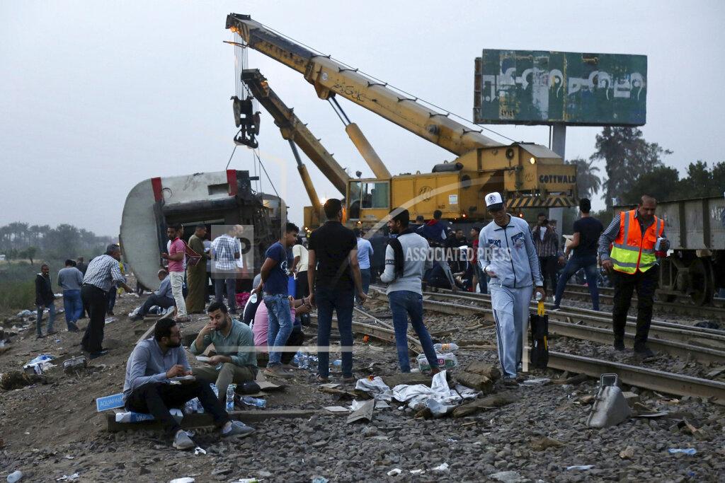 Fadel Dawood People break their fast during the holy month of Ramadan, at the site of a passenger train that derailed injuring around 100 people, near Banha, Qalyubia province, Egypt, Sunday, April 18, 2021. The train was travelling to the Nile Delta city of Mansoura from the Egyptian capital, the statement said. (AP Photo/Fadel Dawood)