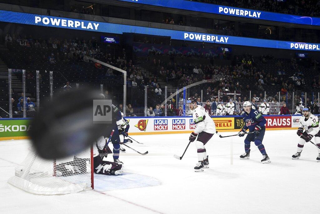 Emmi Korhonen Karlis Cukste (2) and Martins Dzierkals (17) of Latvia and Adam Gaudette (17) of USA follow the puck as goalkeeper Elvis Merzlikins of Latvia made a save during USA powerplay, during their group B Hockey World Championship match in Tampere, Finland, Friday May 13, 2022. (Emmi Korhonen/Lehtikuva via AP)