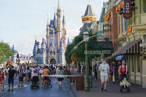 FILE - Guests stroll along Main Street at the Magic Kingdom theme park at Walt Disney World, Monday, Aug. 30, 2021, in Lake Buena Vista, Fla. Cooped-up tourists eager for a taste of Florida's sandy beaches, swaying palm trees and warmer climates are visiting the Sunshine State in droves, topping pre-pandemic levels in recent months. (AP Photo/John Raoux, File)