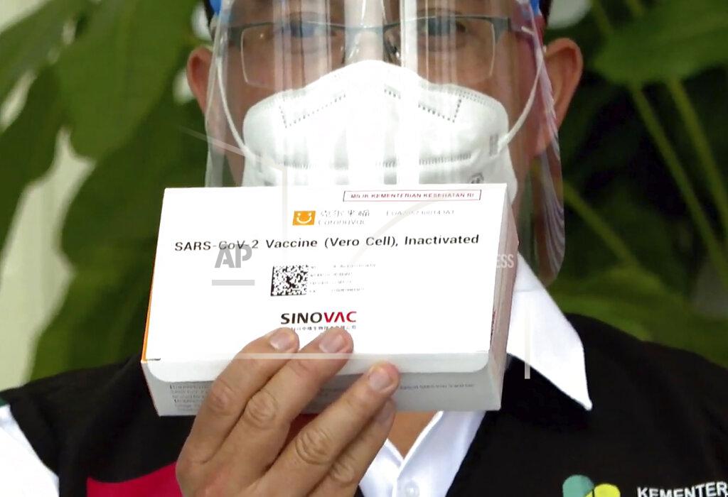In this image made from a video released by Indonesian Presidential Palace, a Health Ministry official shows a box of COVID-19 vaccine that will be given to President Joko Widodo at Merdeka Palace in Jakarta, Indonesia, Wednesday, Jan. 13, 2021. Widodo on Wednesday received the first shot of a Chinese-made COVID-19 vaccine after Indonesia approved it for emergency use and began efforts to vaccine millions of people in the world's fourth most populated country. (Indonesian Presidential Palace via AP)