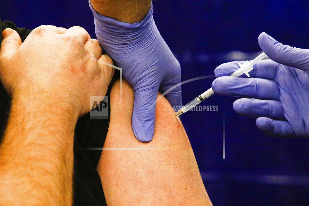 A worker receives a Pfizer-BioNTech COVID-19 vaccine shot at Franciscan Health Crown Point, Friday, Dec. 18, 2020, in Crown Point, Ind. Region hospitals are providing shots to frontline healthcare workers as the vaccine is being initially distributed in the area. (Kale Wilk/The Times via AP)