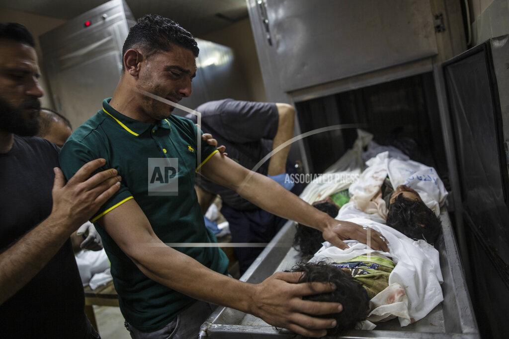 Khalil Hamra A Palestinian relative mourns over the bodies of four young brothers from the Tanani family who were found under the rubble of a destroyed house following Israeli airstrikes in Beit Lahiya, northern Gaza Strip, Friday, May 14, 2021. (AP Photo/Khalil Hamra)