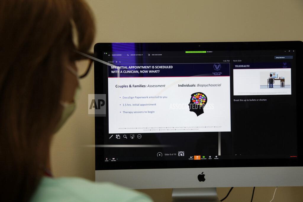 Margo Jarvis takes part in video teleconference at Cohen Veteran's Network's on Wednesday, April 22, 2020, in Fayetteville, N.C. Since the pandemic began, the organization has pivoted their mental health services to telehealth at their 15 clinics across the United States. (AP Photo/Sarah Blake Morgan)