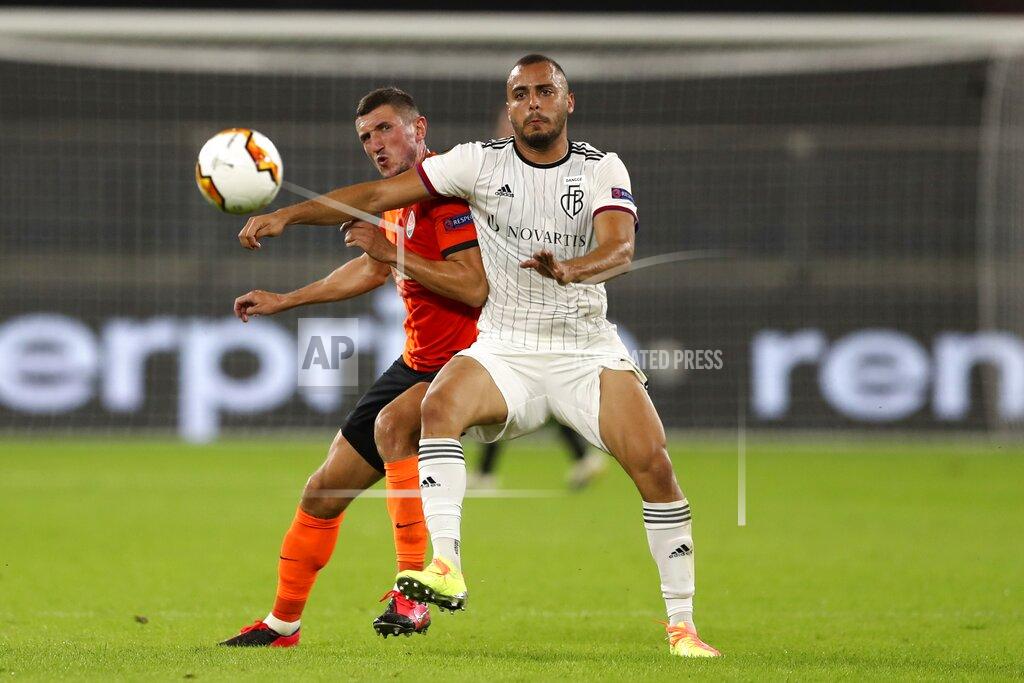 Lars Baron Shakhtar's Serhiy Kryvtsov, left, and FC Basel's Arthur Cabral fight for the ball during the Europa League quarter-final soccer match between Shakhtar Donetsk and FC Basel at the Veltins-Arena in Gelsenkirchen, Germany, Tuesday, Aug. 11, 2020. (Lars Baron/Pool via AP)