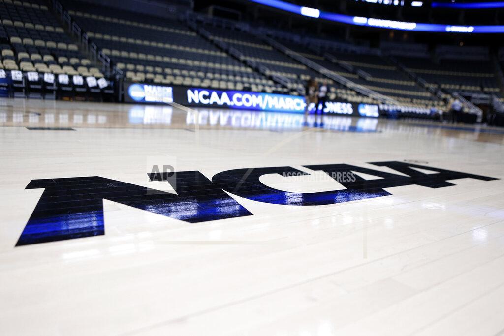 Keith Srakocic FILE - In this March 18, 2015, file photo, the NCAA logo is displayed on the court as work continues at The Consol Energy Center in Pittsburgh. Coaches did the best they could to prepare for the big moment, yet still find themselves in a scramble once it actually happened. The NCAA announced last month that the season would begin on Nov. 25 and teams are still trying to fill all the holes in their schedules. (AP Photo/Keith Srakocic, File)