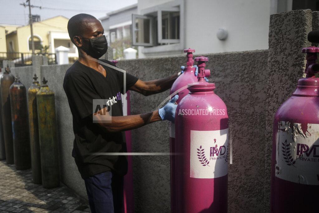 Sunday Alamba A worker from a private medical service brings oxygen bottles to aid the recovery of a COVID-19 patient, at her home in Lagos, Nigeria on Saturday, Feb. 6, 2021. A crisis over the supply of medical oxygen for coronavirus patients has struck nations in Africa and Latin America, where warnings went unheeded at the start of the pandemic and doctors say the shortage has led to unnecessary deaths. (AP Photo/Sunday Alamba)