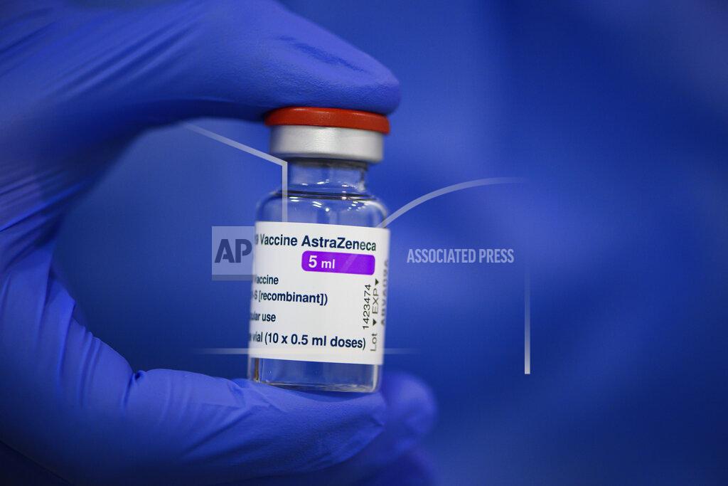 Robert Michael FILE - In this March 20, 2021 file photo an employee at the vaccination centre at Messe Dresden holds a vial of Astrazeneca's active ingredient against Corona in his hand in Dresden, Germany. Countries in the European Union have ramped up the vaccination after sluggish start. The uptick comes as countries across Europe also grapple with a rise in infections that has pushed the EU’s overall number of confirmed cases close to 30 million.(Robert Michael/dpa via AP, file)