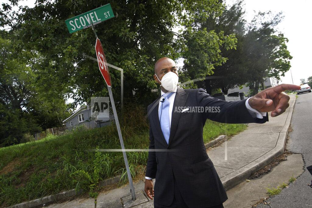 John Amis Tennessee State Rep. Harold Love, Jr. points toward interstate I-40 as he walks down his family's former street on the north side Monday, July, 19, 2021, in Nashville, Tenn. Love Jr.'s father, a Nashville city councilman, was forced to sell his family home here to make way for the highway, but put up a fight in the 1960s against the rerouting of Interstate 40 because he believed it would stifle and isolate Nashville's Black community. Love Jr. is now part of a group pushing to build a cap across the highway that creates a community space to help reunify the city. (AP Photo/John Amis)