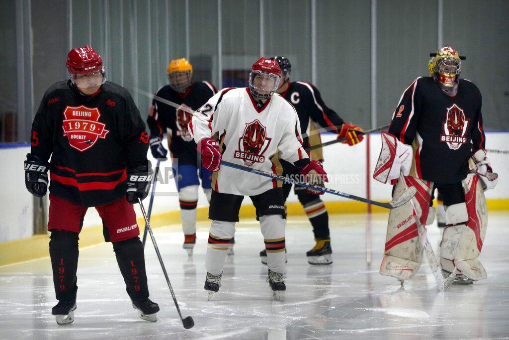Mark Schiefelbein Members of the "1979" hockey club warm up on the ice before a hockey match at a rink in Beijing, Wednesday, Jan. 12, 2022. Spurred by enthusiasm after China was awarded the 2022 Winter Olympics, the members of a 1970s-era youth hockey team, now around 60 years old, have reunited decades later to once again take to the ice. (AP Photo/Mark Schiefelbein)