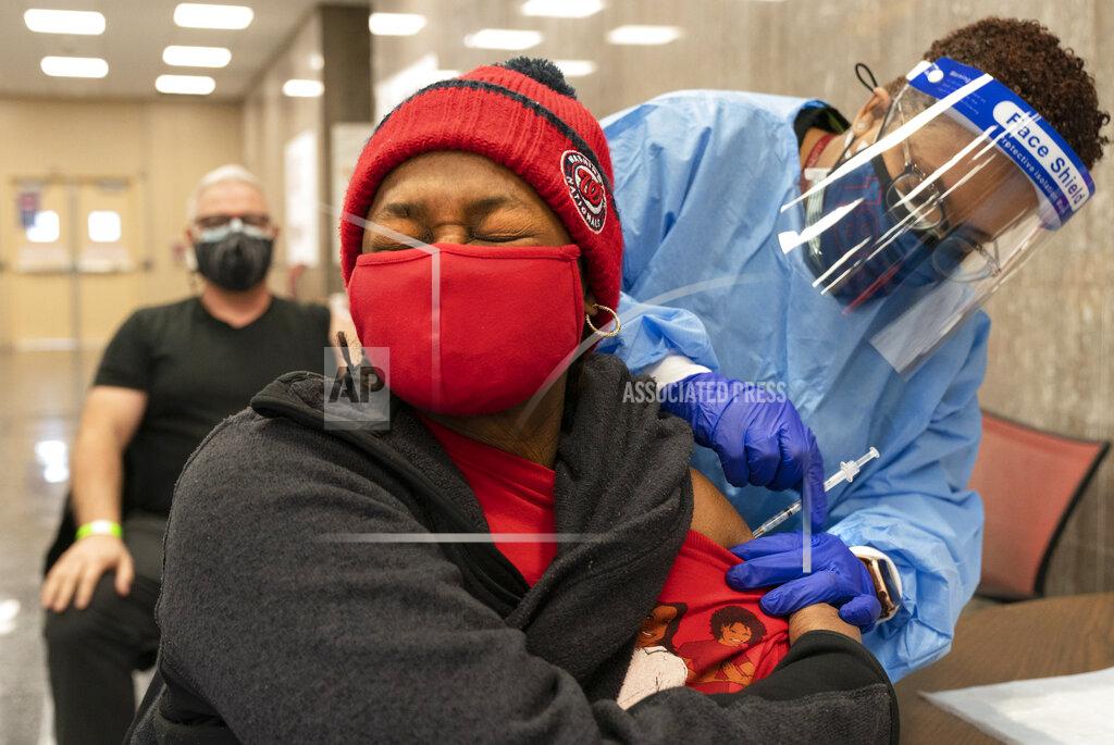 Jacquelyn Martin In this Thursday, Feb. 11, 2021, photo Jorie Winbish, 56, of Washington, reacts as she receives her second dose of the COVID-19 vaccine at a clinic at Howard University, in Washington. "I feel so lucky to have number two in my arm," says Winbish. (AP Photo/Jacquelyn Martin)