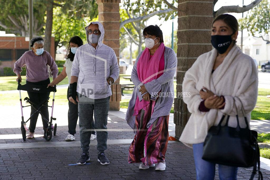 Marcio Jose Sanchez FILE - In this March 23, 2021, file photo, people line up at a COVID-19 vaccination site, Tuesday, March 23, 2021, in Bell, Calif. As Newsom faces a likely recall, Latino advocates say engaging their communities and providing a more robust response to the pandemic could be keys to his survival. (AP Photo/Marcio Jose Sanchez, File)