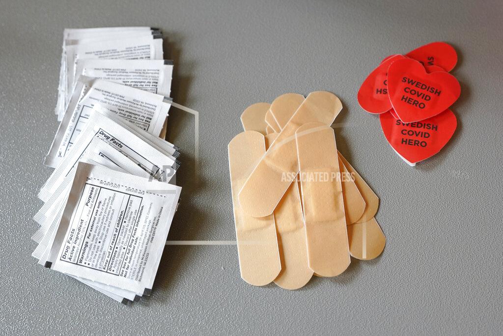 Ted S. Warren Alcohol swabs, adhesive bandages, and heart-shaped stickers that read "Swedish COVID Hero" are shown at a mass vaccination clinic at Seattle University put on by Swedish Medical Center, Friday, Feb. 26, 2021, in Seattle. As states ramp up vaccination distribution in the fight against the coronavirus, volunteers are needed to do everything from direct traffic to check people in to keep vaccination sites running smoothly. (AP Photo/Ted S. Warren)
