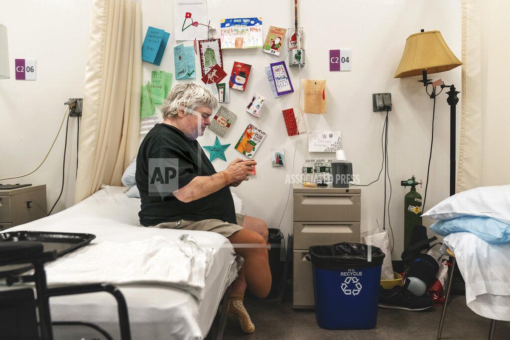 David Goldman Holiday cards decorate the wall beside the bed of COVID-19 patient Art Singleton, 56, at a field hospital set up to handle a surge of COVID-19 patients Wednesday, Jan. 6, 2021, in Cranston, R.I. The hospital asked the community to send cards to patients, as well as health care workers caring for them; more than 5,000 were received. (AP Photo/David Goldman)