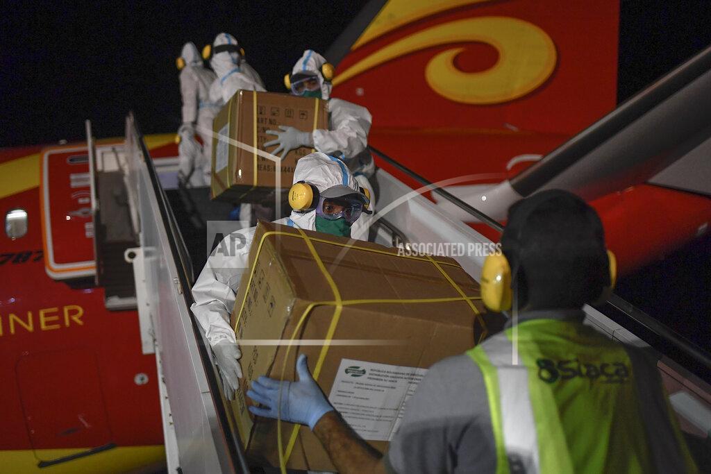Matias Delacroix FILE - In this March 30, 2020 file photo, Venezuelan workers, wearing protective face masks and suits as a preventive measure against the spread of the new coronavirus, unload humanitarian aid from China at the Simon Bolivar International Airport in La Guaira, Venezuela. China donated more than $215 million in supplies to allies in the region, and conducted clinical trials or plans to manufacture vaccines in five countries. (AP Photo/Matias Delacroix, File)