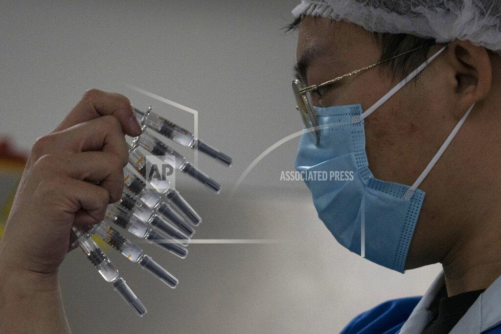 Ng Han Guan FILE - In this Thursday, Sept. 24, 2020 file photo, a worker inspects syringes of a vaccine for COVID-19 produced by Sinovac at its factory in Beijing. Sinovac and Sinopharm both rely on a traditional technology called an inactivated virus vaccine, based on cultivating batches of the virus and then killing it. (AP Photo/Ng Han Guan)