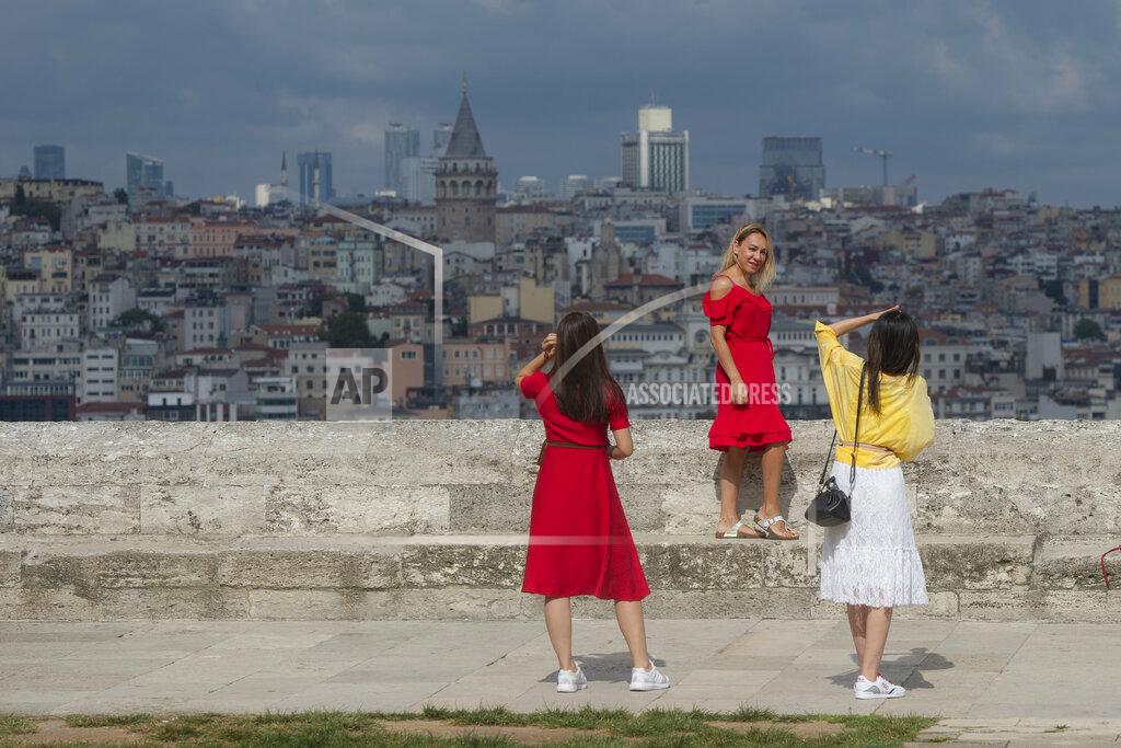 Yasin Akgul Backdropped by Istanbul's iconic Galata Tower, people take pictures in Istanbul, Friday, Sept. 11, 2020. Turkey is getting tough on people who flout self-isolation rules despite testing positive for the coronavirus. An Interior Ministry circular sent to the country's 81 provinces on Friday said people caught leaving their homes despite isolation orders will be quarantined and supervised at state-owned dormitories or hostels. (AP Photo/Yasin Akgul)