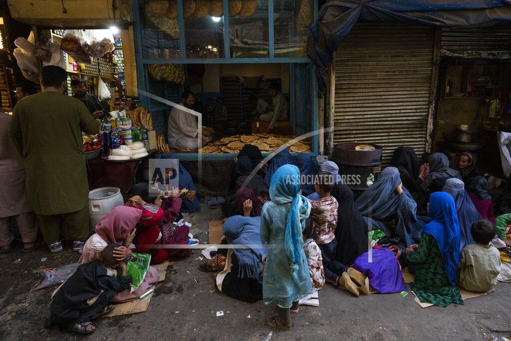 Bernat Armangue Afghan women and children sit in front of a bakery waiting for bread donations in Kabul's Old City, Afghanistan, Thursday, Sept. 16, 2021. (AP Photo/Bernat Armangue)