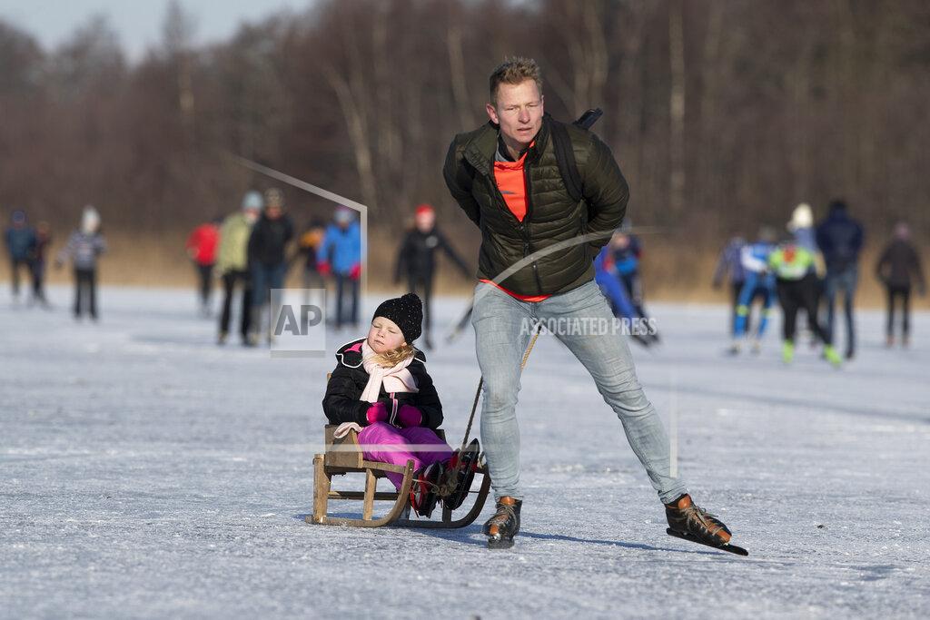 Peter Dejong People skate on Nannewiid Lake in Oudehaske, Netherlands, Friday, Feb. 12, 2021. With many lakes and canals in the Netherlands frozen over, Dutch skating fans flocked to the ice Friday, causing a headache for authorities trying to enforce social distancing measures to stop the spread of the coronavirus. (AP Photo/Peter Dejong)
